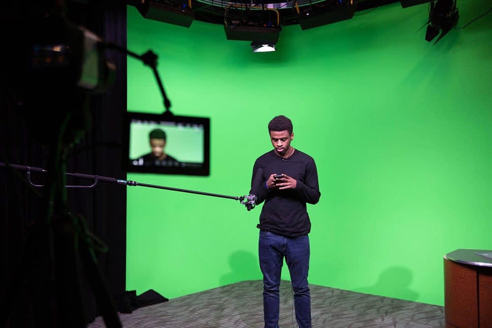 Guy filming in front of Green Screen